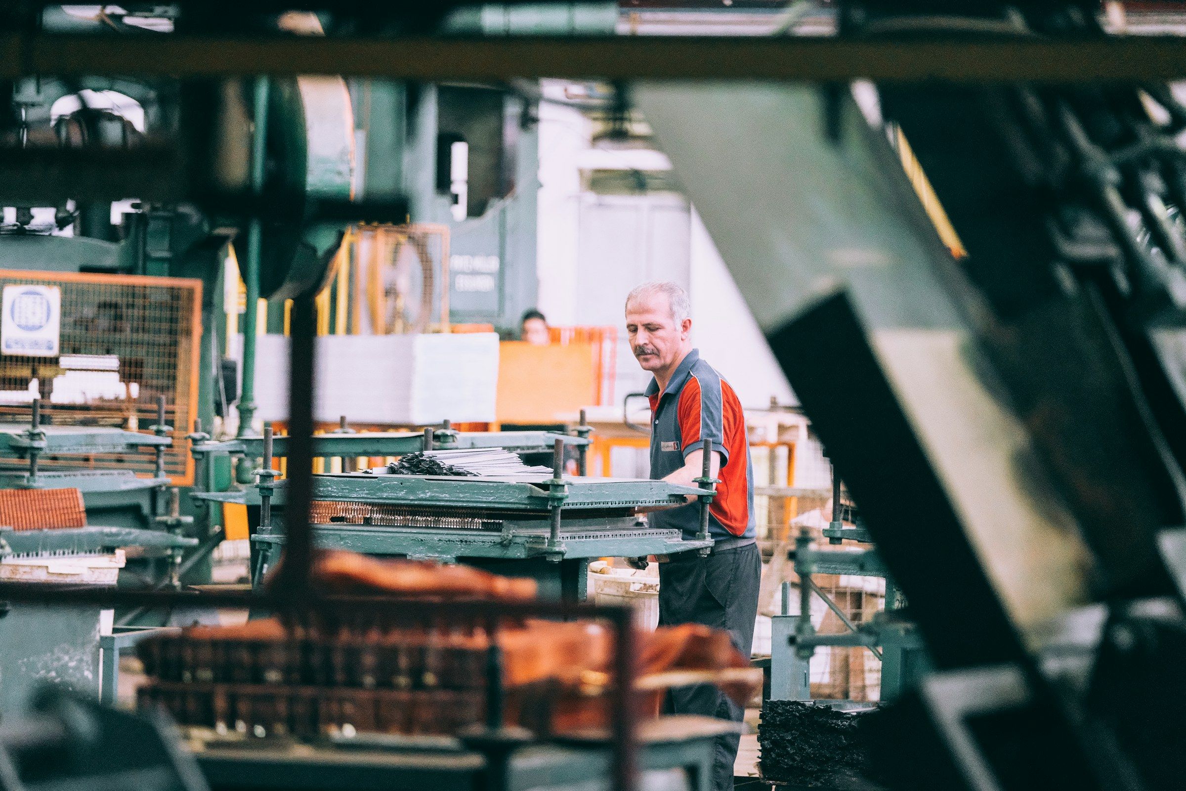 Un opérateur règle une machine dans un atelier de production.