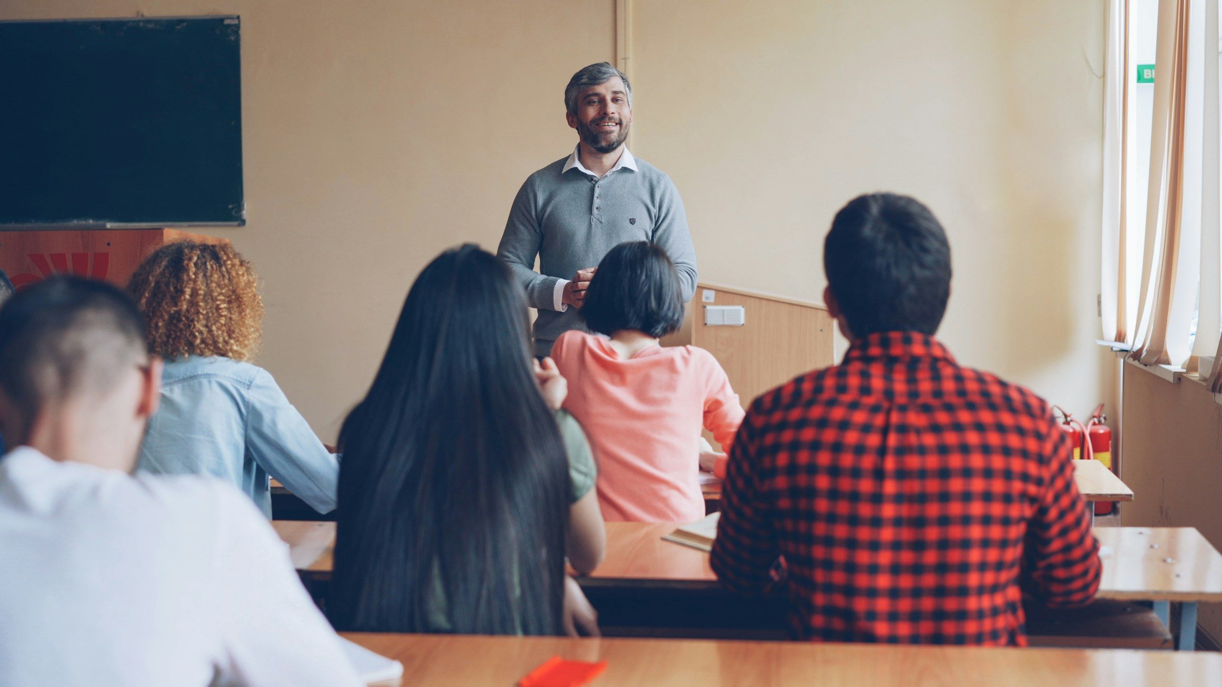 Un enseignant répond aux questions d’étudiants dans une salle de cours.